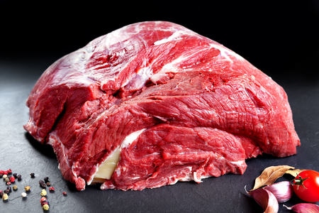 Fresh and raw meat. Whole piece of red meat ready to cook on the grill or BBQ .background black blackboardの写真素材