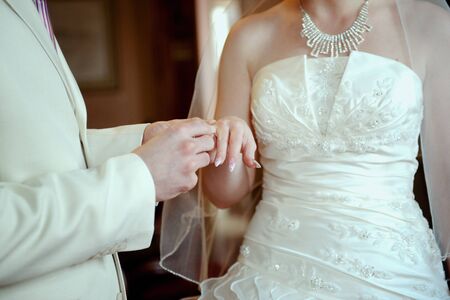 Hands of married pair with a beautiful wedding ringの写真素材