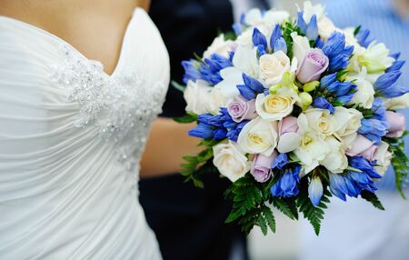 Wedding decor  Beautiful wedding bouquet of roses in the hands of the bride