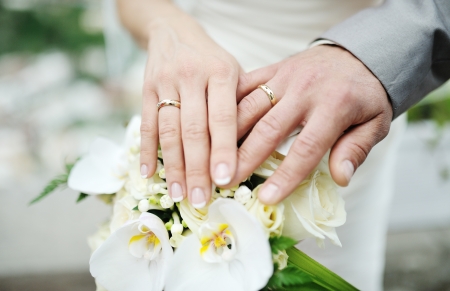 bride and groom showing wedding rings on wedding bouquetの写真素材