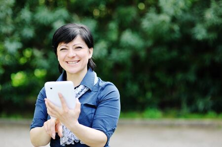 pretty cheerful smiling caucasian woman using tablet computerの写真素材