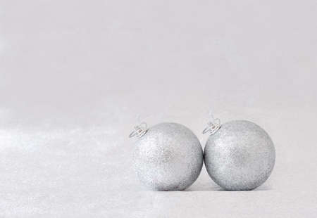 two silver balls for the Christmas tree on gray backgroundの写真素材
