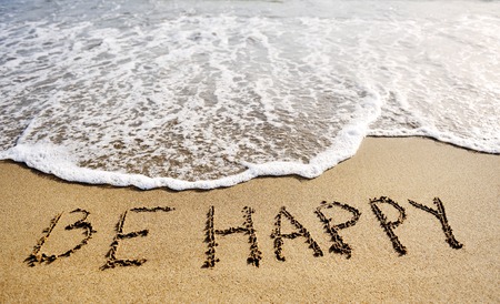 be happy words written on the sand of the beach - positive thinking concept