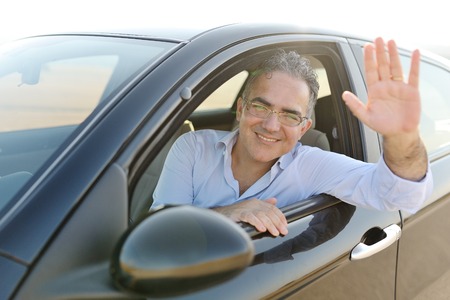 smiling caucasian man sitting in his new car