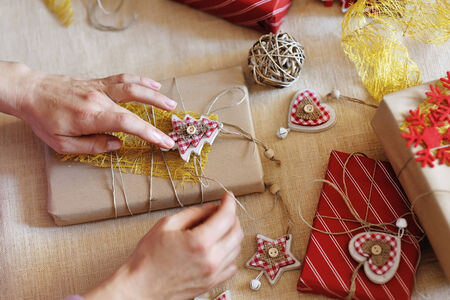 woman hands wrapping christmas gift box and decorations