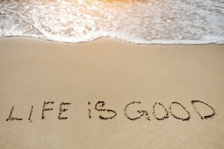 life in good written on the sand beach - positive thinking concept