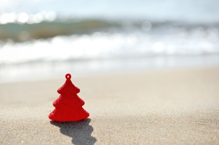 red christmas tree decoration on sand beachの写真素材