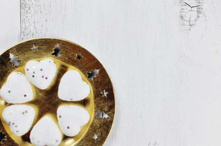 yellow plate and white hearts christmas decoration on wooden backgroundの写真素材