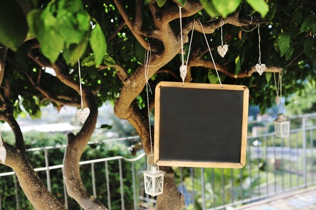 Blackboard, lantern and heart shaped decorations on a tree for the wedding partyの写真素材