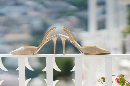 Bridal beige shoes on a white railing - wedding accessoryの写真素材
