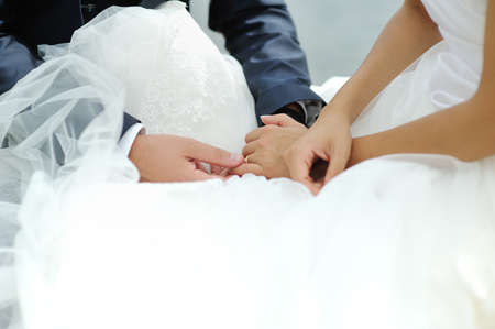 Groom tenderly touching bride hand during wedding ceremony
