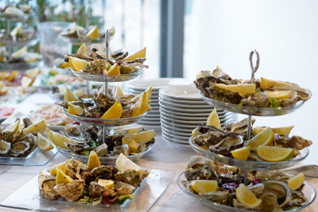 Opened fresh oysters with lemon in glass dishの写真素材