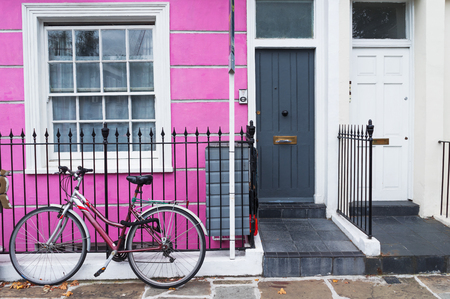 London, England, UK - typical colored british house and a bicycle on the fenceの写真素材
