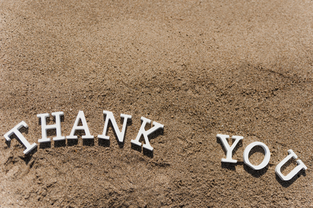 thank you words written on the sand of the beachの写真素材