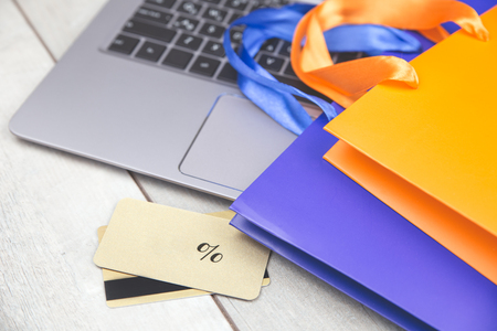 Shopping bags, credit card, laptop on deskの写真素材