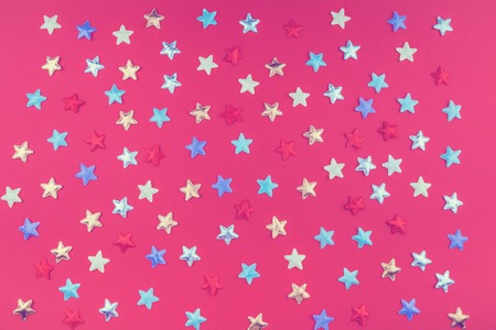 Background of assorted color stars scattered on red background flat layの写真素材