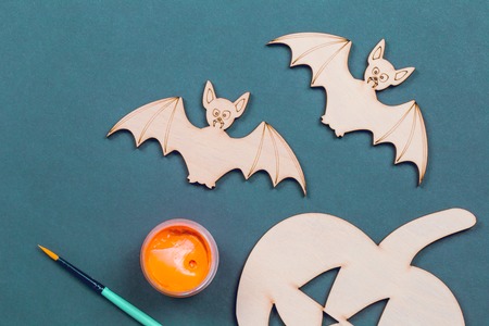 Do it yourself Halloween pumpkin and vampire bats cut outs on a colorful background in flat lay with paint and brushの写真素材