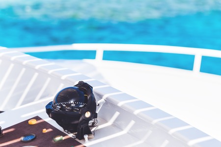 Compass on a white yacht overlooking blue sea. Boat trip travel and exotic vacation conceptの写真素材