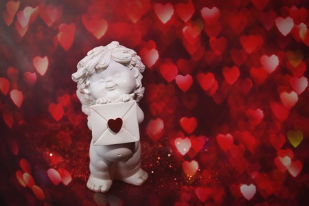Cherub baby angel with heart and bokeh. St Valentine card, love and sentiment conceptの写真素材