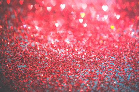 Abstract red heart glitter light bokeh holidayand festive party background. Love sentiment and St Valentines day card concept with copy spaceの写真素材