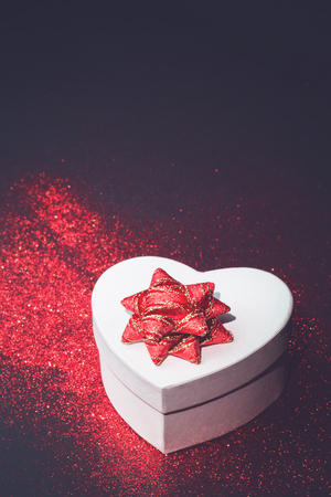 Heart shaped gift box with red glitter. Passion, love and feelings St Valentine's celebration concept with copy spaceの写真素材