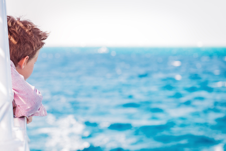 One red haired boy enjoying a boat sea trip. Travel destination and family vacation conceptの写真素材