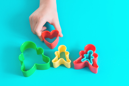 Happy family concept cut outs in hands of a child. Mother, father, son, daughter and pregnancy top view with copy spaceの写真素材