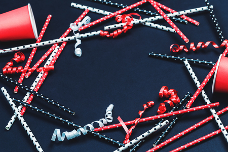 Dotted paper straws background close up, red white and black party or celebration concept beyond plastic flat lay layout with copy spaceの写真素材