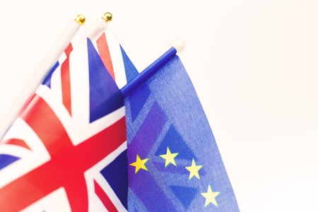 Background of EU and UK waving flags, part of Union Jack visible with copy space. Brexit and...