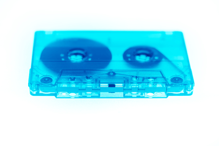 Trendy reviving retro audio cassette tape transparent neon blue isolated on white. Analogue music hipster trendの写真素材