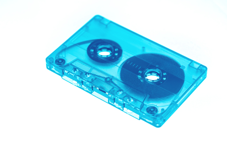 Trendy reviving retro audio cassette tape transparent neon blue isolated on white. Analogue music hipster trendの写真素材
