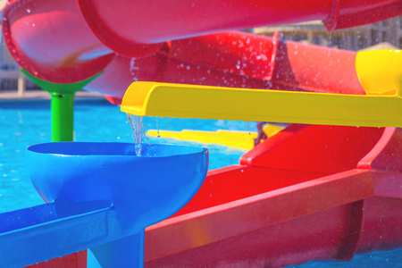 Happy cheerful boy having fun on water slide at aqua park. Summer recreation and family vacation conceptの写真素材
