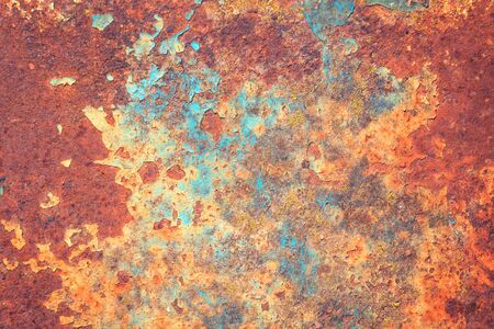 Old grungy cracked blue weathered wall paint peeling off rusted metal sheet. Textured background for...