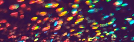 Multicolor blurred neon lights star flares and rainbow glitter on dark background. Bokeh lens flare...