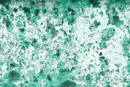 Old grungy cracked green weathered wall paint peeling off rusted metal sheet. Textured monochromatic...