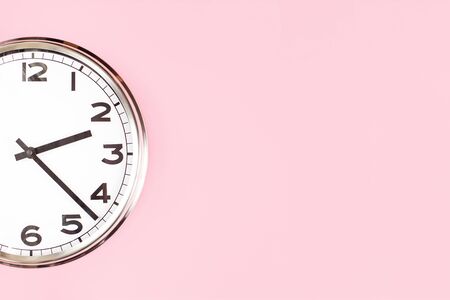Part of big analogue plain wall clock on candy pink background. Close up with copy space, time...