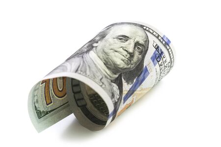 Isolated curled hundred dollars note closeup on white. Finance markets investments loans earnings...
