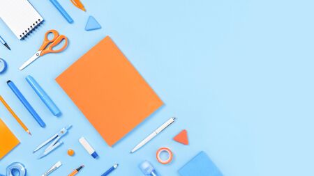 Assorted office and school white orange and blue stationery on pastel trendy background as border. Flat lay with copy space for back to school or education and craft concept. Blue monochrome bannerの写真素材