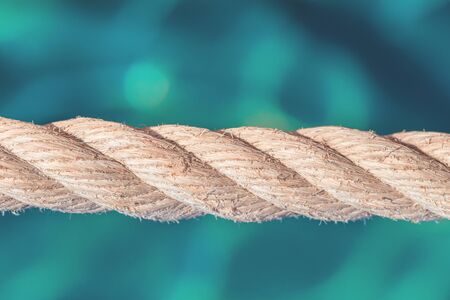 Old boat rope fence against turquoise water at seaside close up. Marine travel or vacation concept...