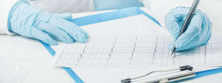 Medicine. Female GP doctor checks the cardiograph. Doctor wearing gloves. Health checkups. Medical advice. Heart disorders concept. Web bannerの写真素材