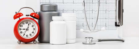 Medicine and pharmacy background. Pills and stethoscope against ECG with printed heart rate. Mockup...
