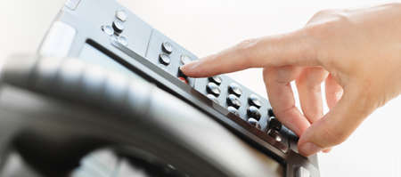 business and communications. Using voip phone in the office, close up of hand of an office staff member. Conference, contact us or message banner. IP telephony, Telemarketing. Help desk or call centreの写真素材