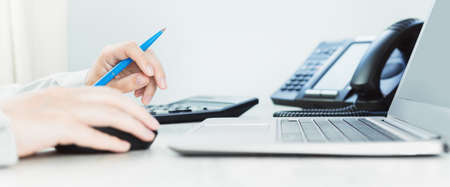 business and communications. Calculator and voip phone in the office, close up of hand. finance...