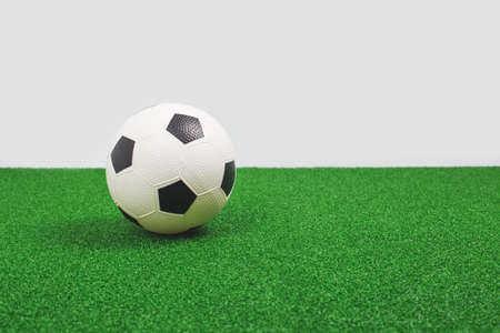 Soccer ball on green turf. Football game or school class concept. Copy space bannerの写真素材