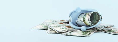 Open coins purse with hundred dollars notes on blue. Finance markets investments loans earnings concept. Personal accounting debts and credits or savings. bankruptcy with copy spaceの写真素材
