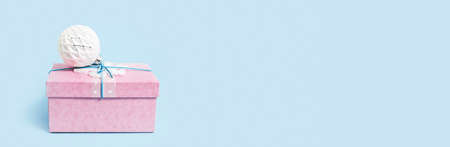 Red Christmas gift box with white bauble on blue. Merry Christmas or Happy New Year greeting card with copy space. Long bannerの写真素材