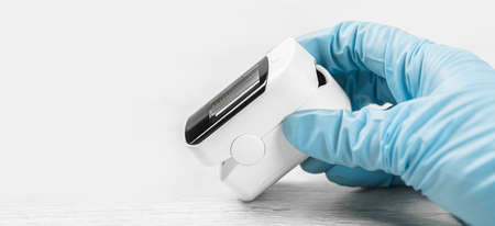 Medical concept. pulse oximeter in hand. Medical protective glove. Pneumonia, covid prevention and...