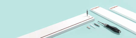 tools for assembly of flat packed furniture on blue background. white diy funiture parts with a...
