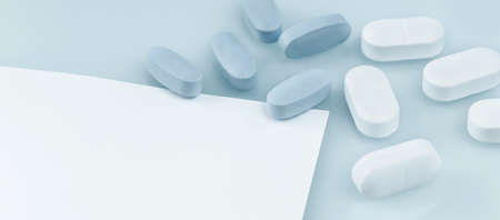 Medical banner. many white and blue capsule tablets or pills on the table. Close up notice copy...