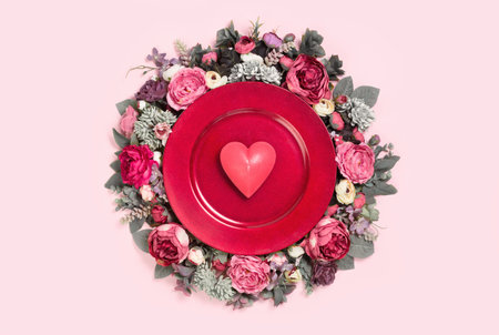 Happy Valentines day card bouquet decorated tray with heart in the middle on soft pink background. Festive floral decoartion edgelessの写真素材